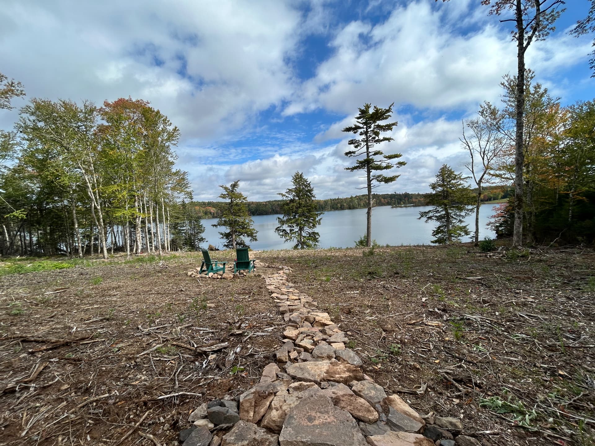 The Nova Scotia property: a view over the lake with two chairs by the fire pit